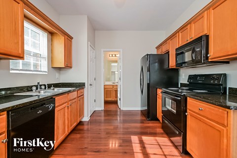 A kitchen with wooden cabinets and black appliances.