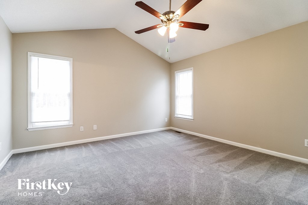 the living room of an empty home with a ceiling fan