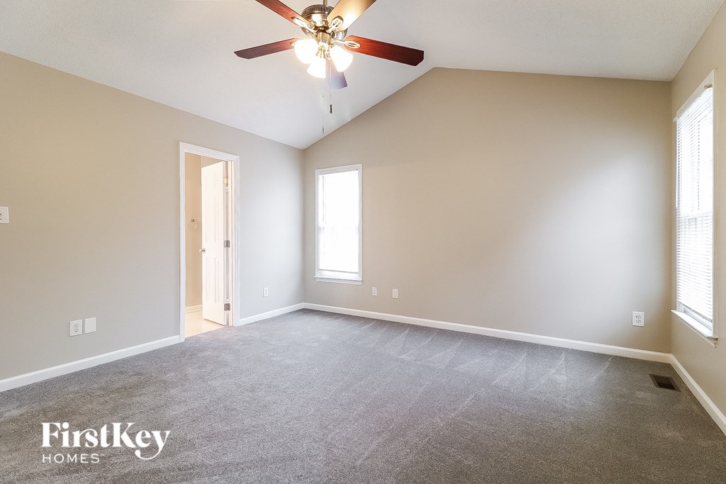 the living room of an empty house with a ceiling fan