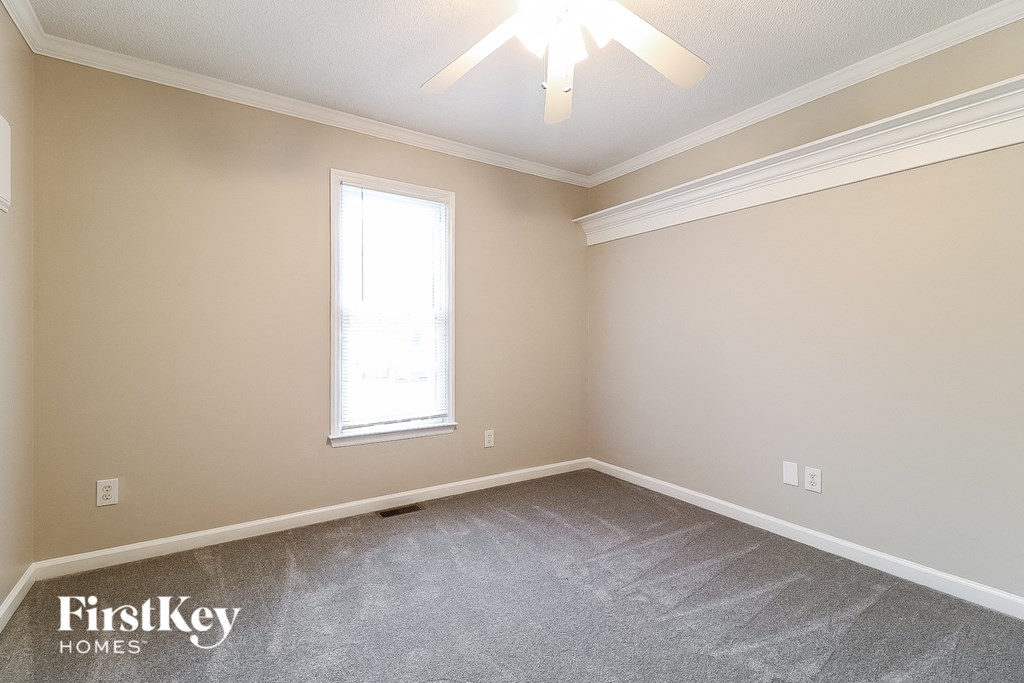a bedroom with a carpeted floor and a window