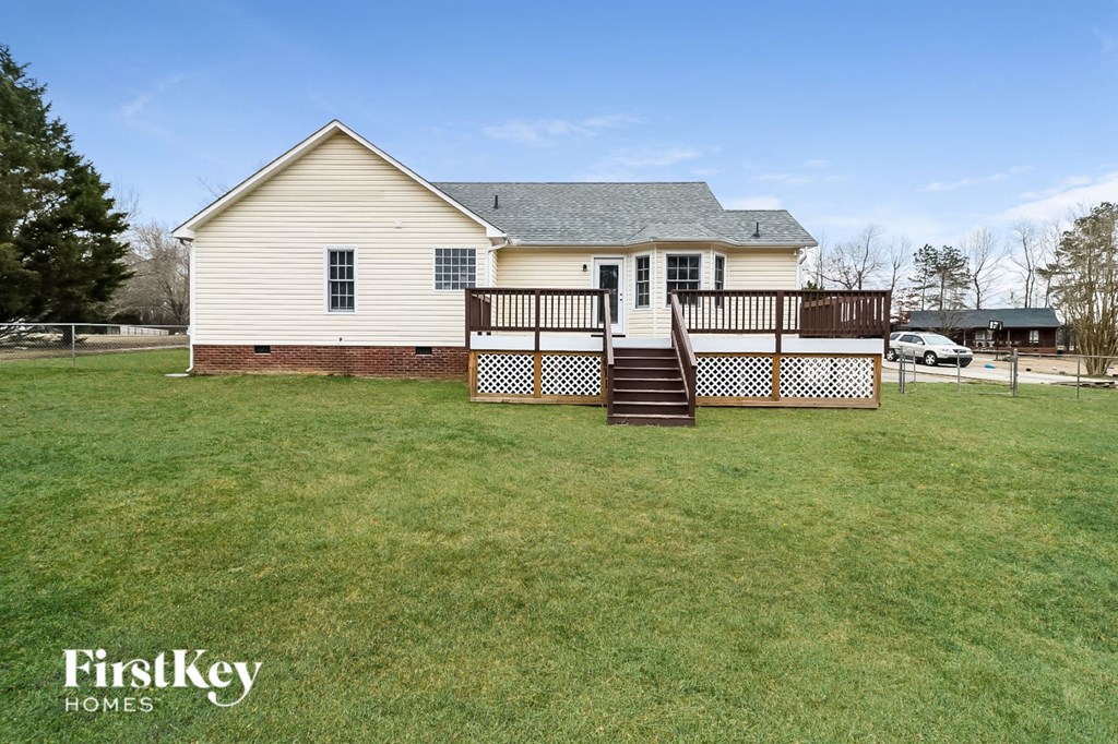 a white house with a deck and a yard
