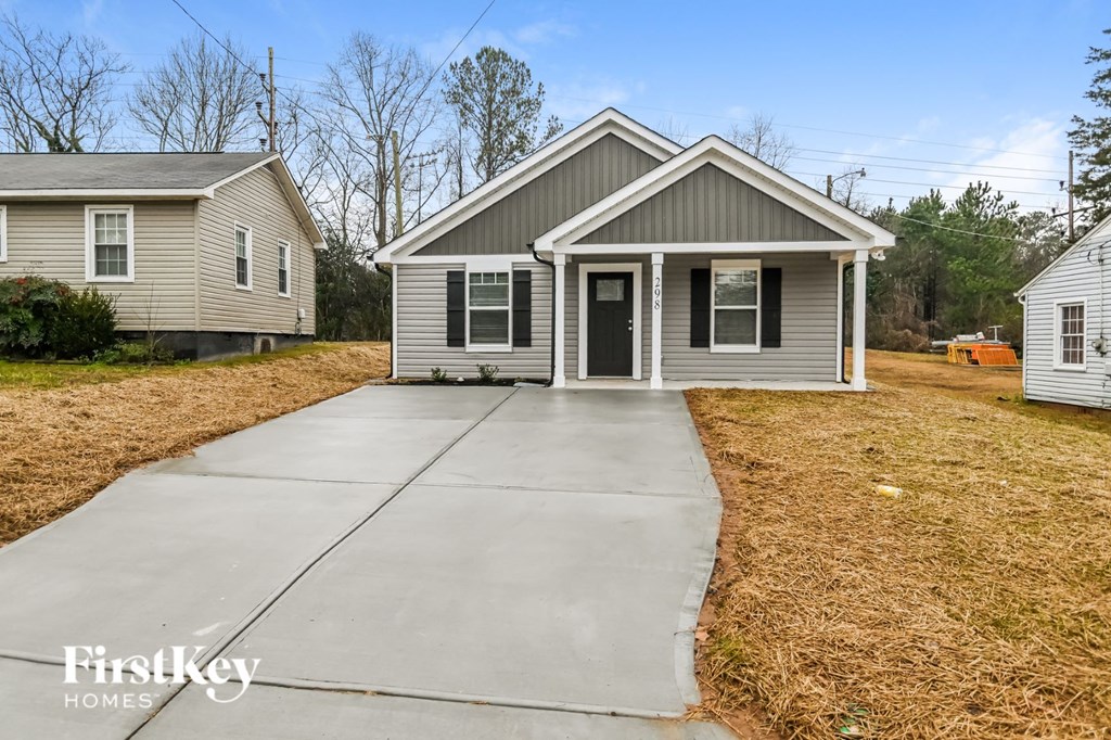 a small gray house with a sidewalk in front of it