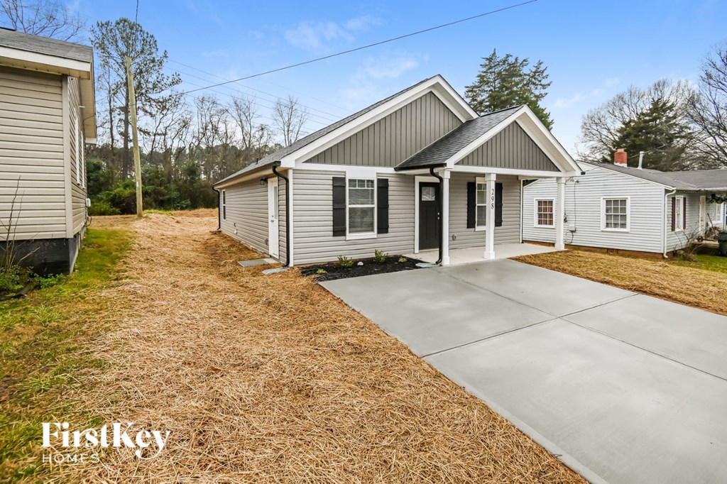 a white house with a concrete driveway in front of it