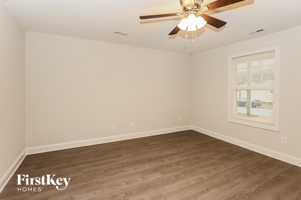 the living room of a home with wooden floors and a ceiling fan