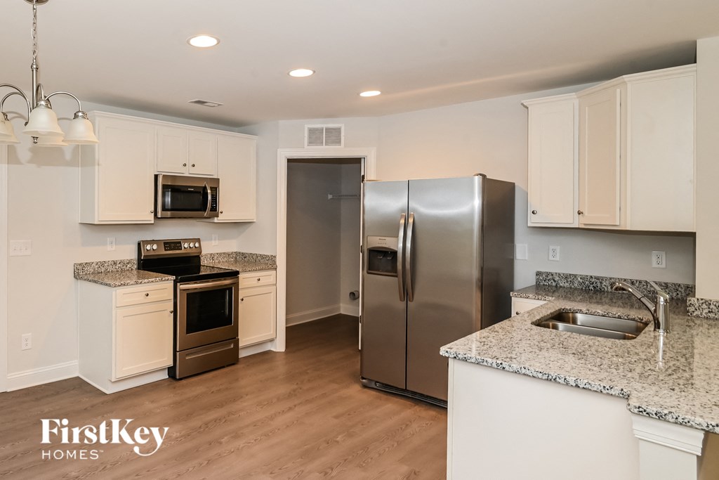 a kitchen with white cabinets and a stainless steel refrigerator