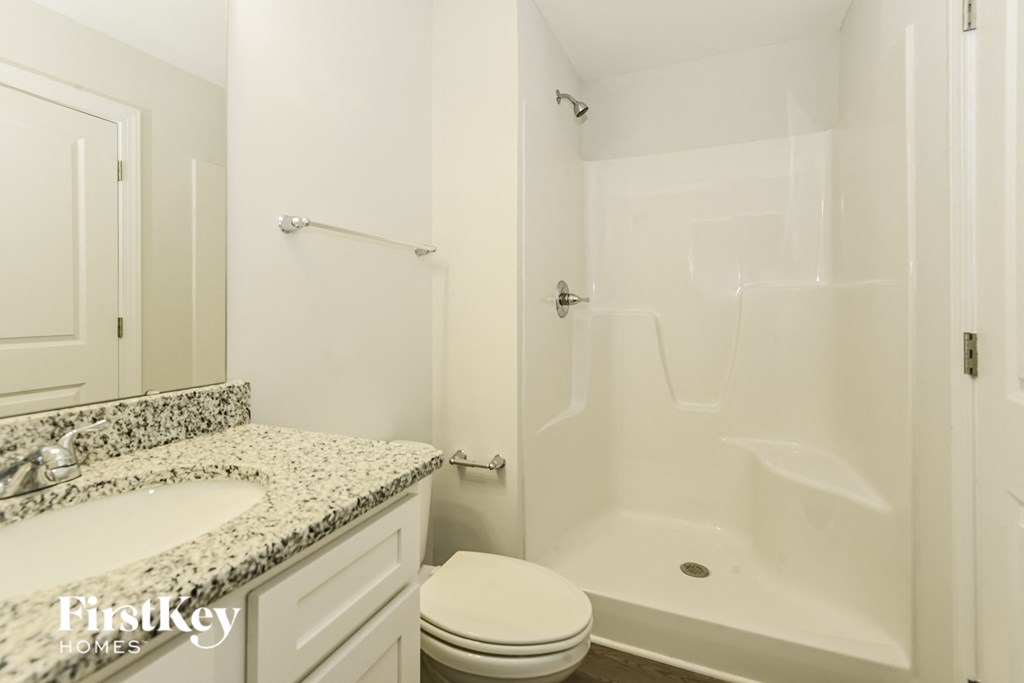 a white bathroom with a tub and a sink and a toilet