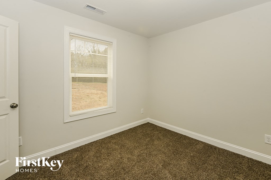 a bedroom with a carpeted floor and a window