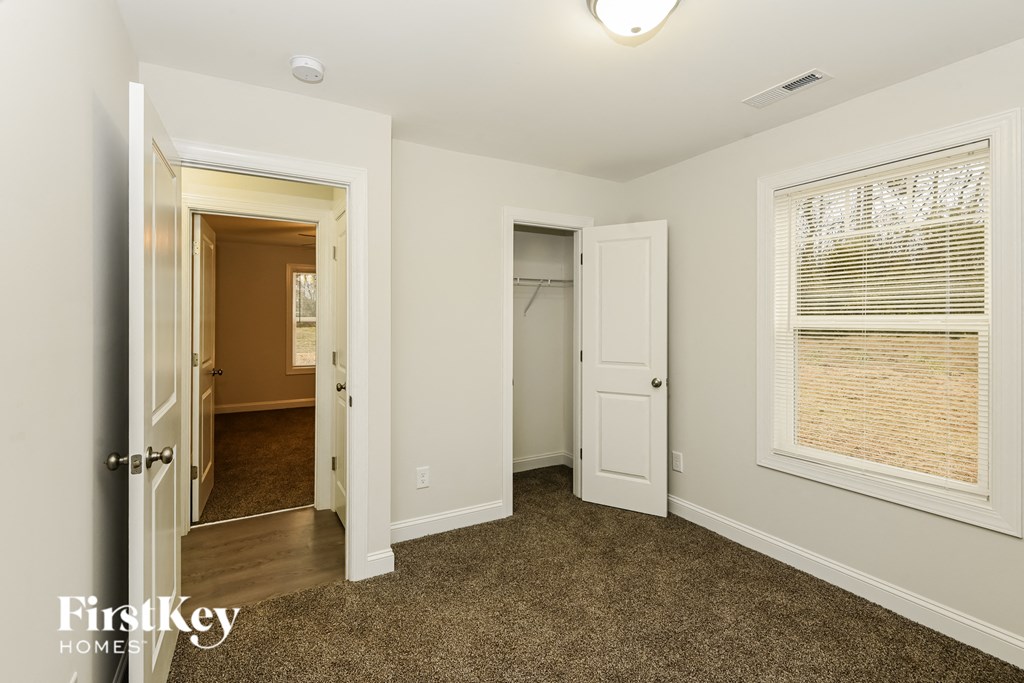 a bedroom with a door to a closet and a window