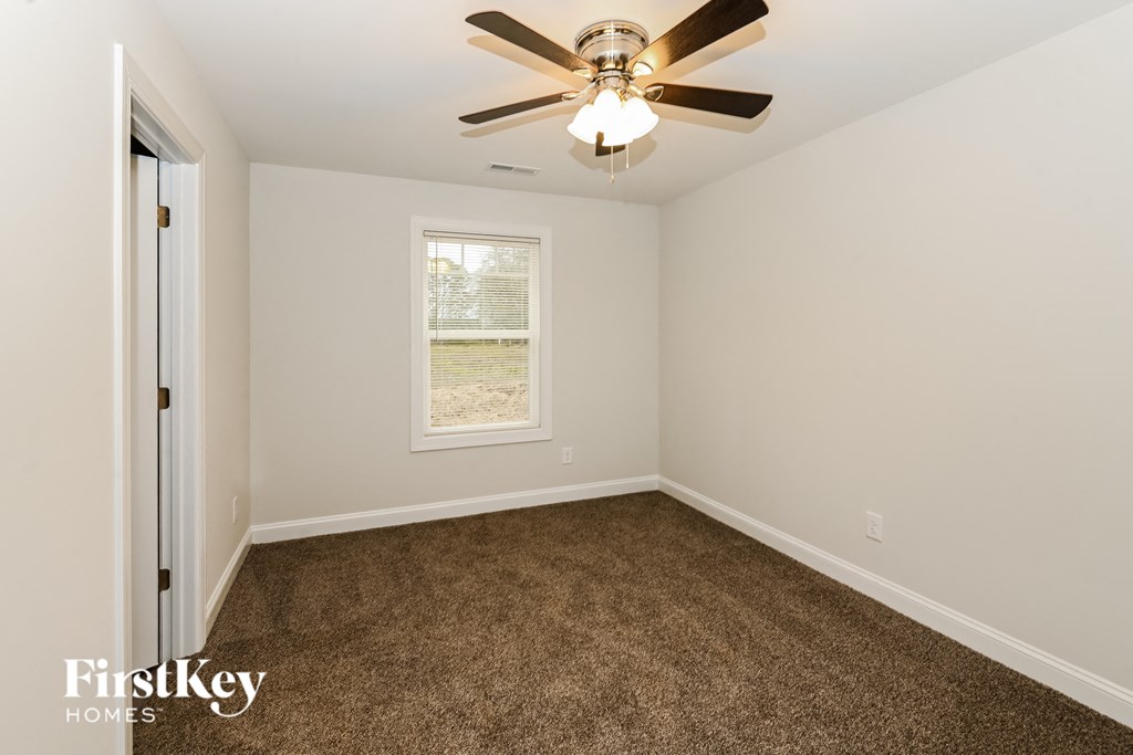 a bedroom with a carpeted floor and a ceiling fan