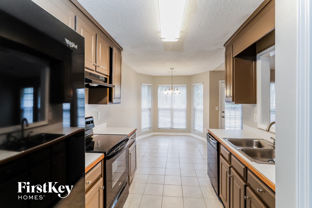 a kitchen with wooden cabinets and black appliances