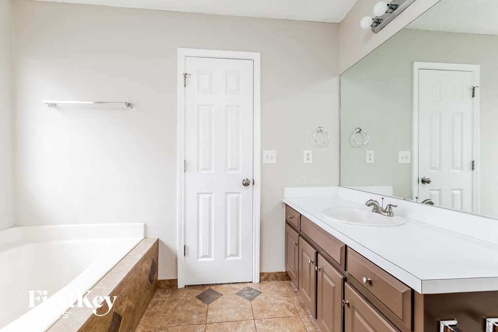 a bathroom with a sink and a tub and a mirror