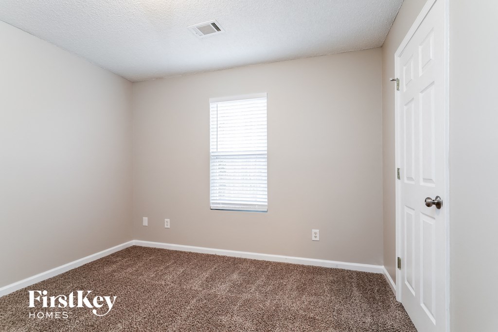 a empty room with carpet and a white door