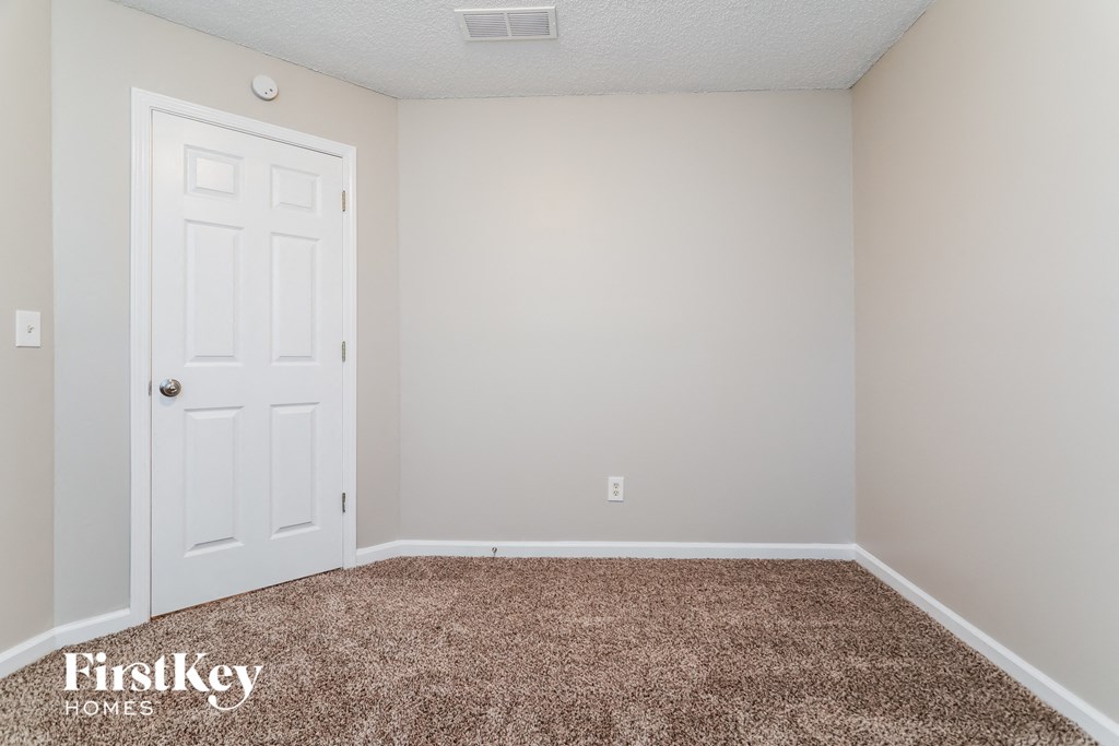 a room with a carpeted floor and a white door