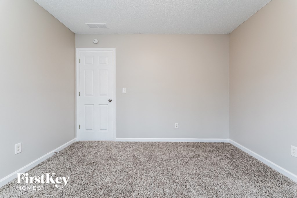 a empty room with carpet and a white door