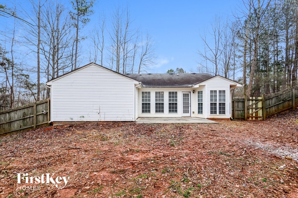a small white house with a yard and a fence