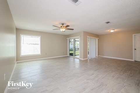 the living room and dining room are spacious and lighted by a ceiling fan