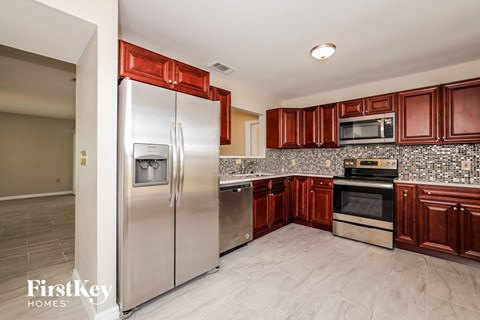 a kitchen with stainless steel appliances and cherry cabinets