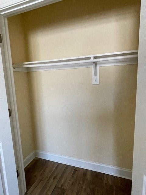 A white closet with a shelf and a door.