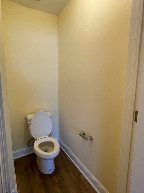 A white toilet in a small room with a door on the right.