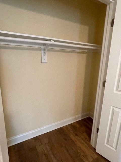 A white door is open to a room with a white wall and a white shelf.
