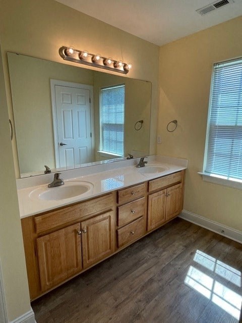 A bathroom with a vanity, sink, mirror, and light strip.