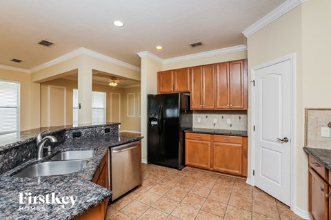 a kitchen with granite counter tops and a black refrigerator