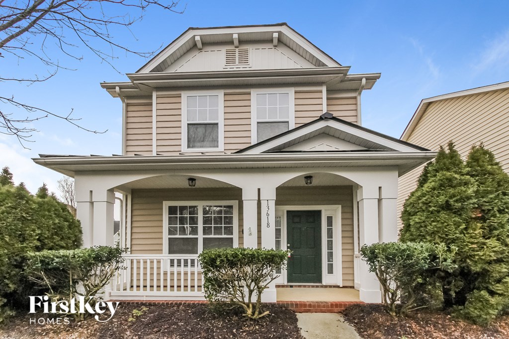 a cream colored house with a green door