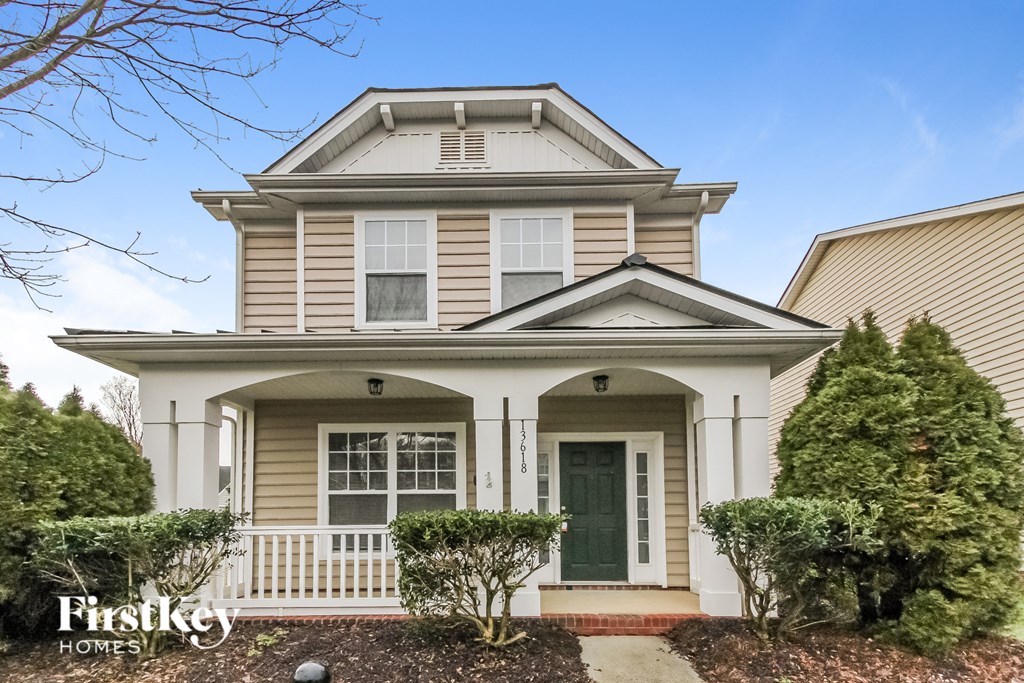 a white and tan house with a green door