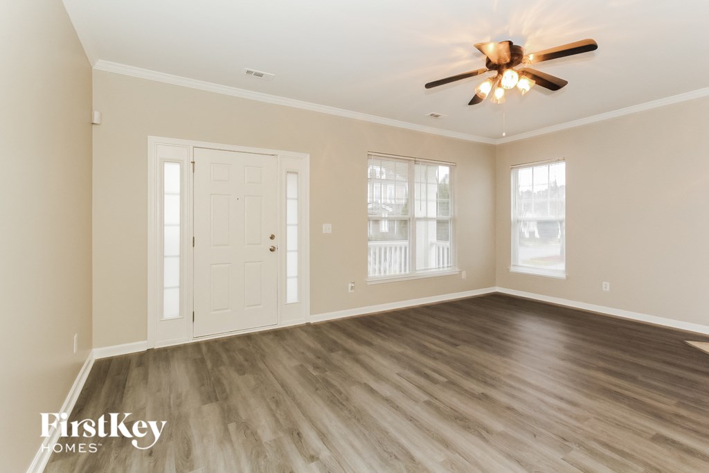 the living room of an empty house with a ceiling fan