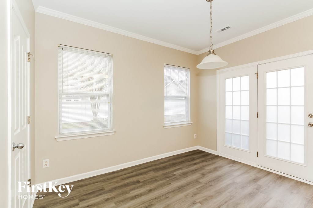 a living room with wood floors and white doors and windows