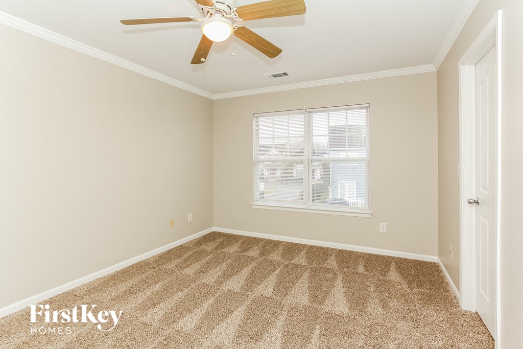a bedroom with carpet and a ceiling fan