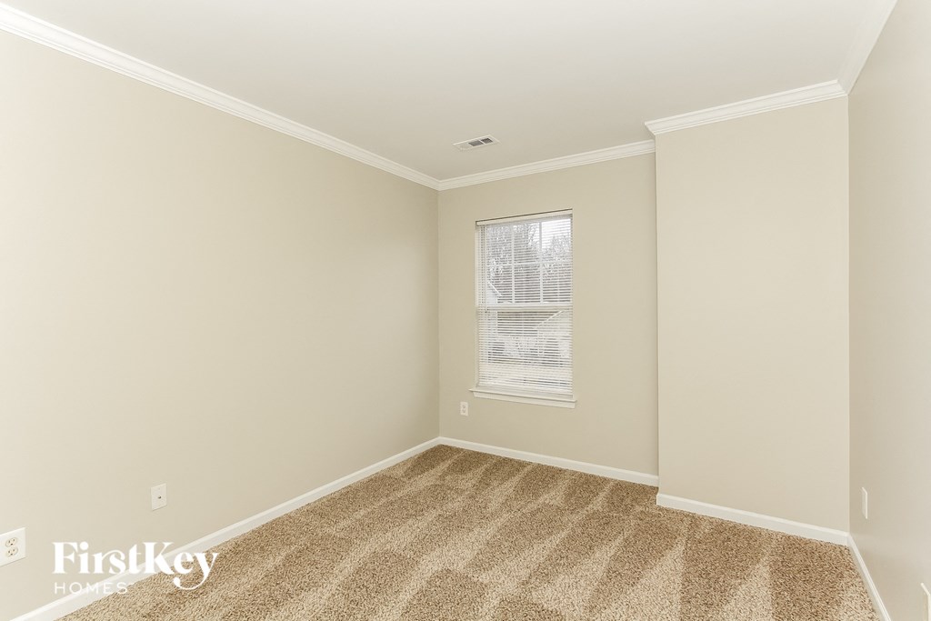 a small room with carpet and a window