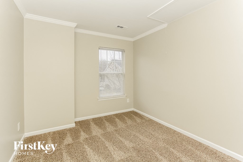 a bedroom with carpet and a window