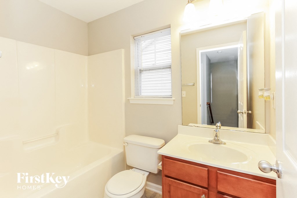 a bathroom with a sink toilet and a mirror