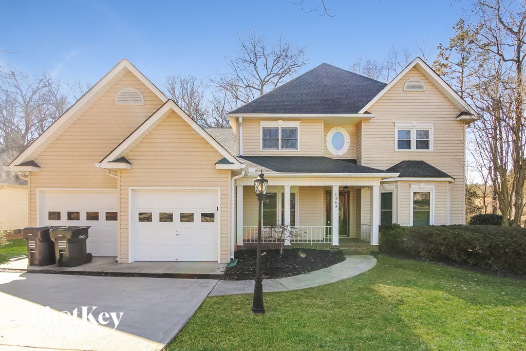 A two-story house with a garage and a driveway.