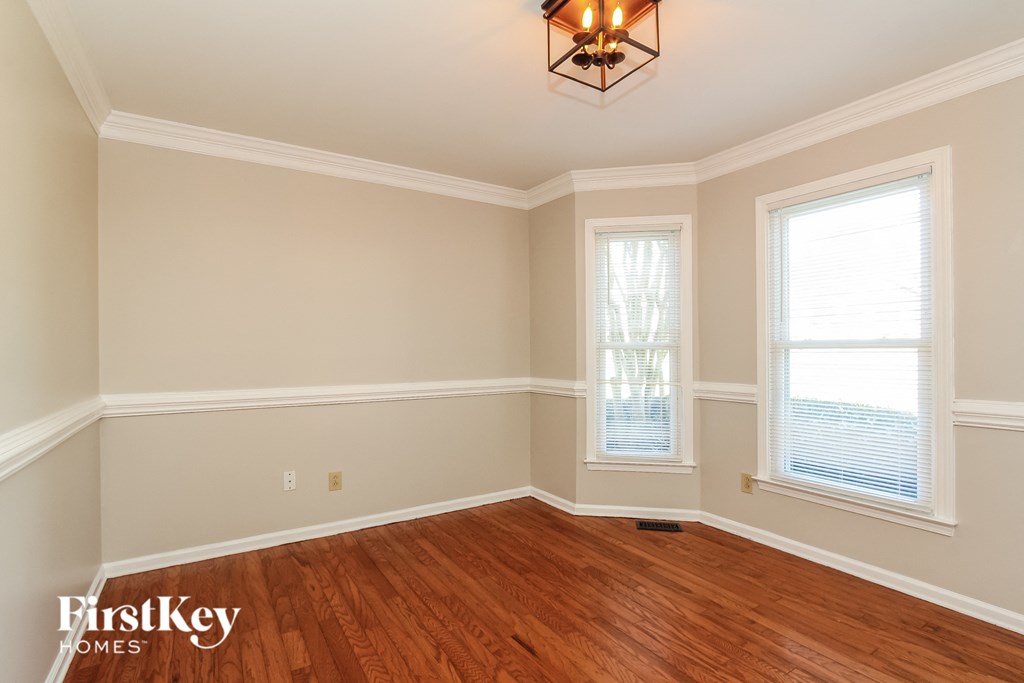 A room with wooden floors and a chandelier hanging from the ceiling.