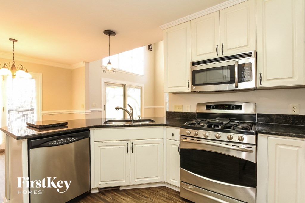 A kitchen with a stove top oven and a microwave above it.