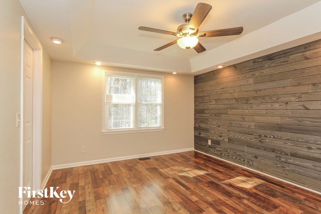 A room with wooden floors and a ceiling fan.