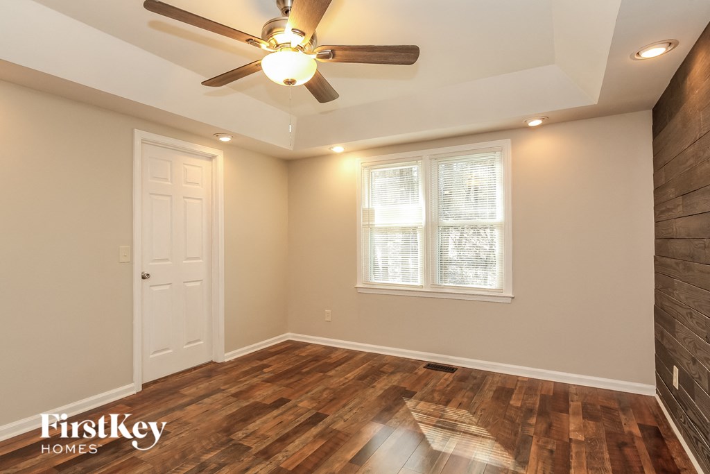 A room with a wooden floor and a ceiling fan.