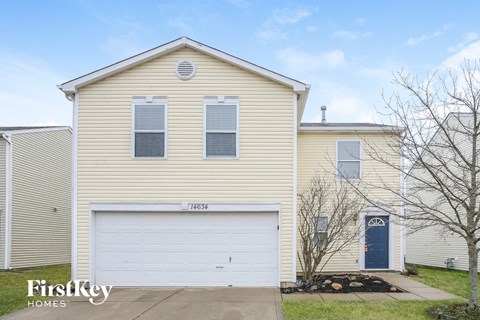 a yellow house with a white garage door