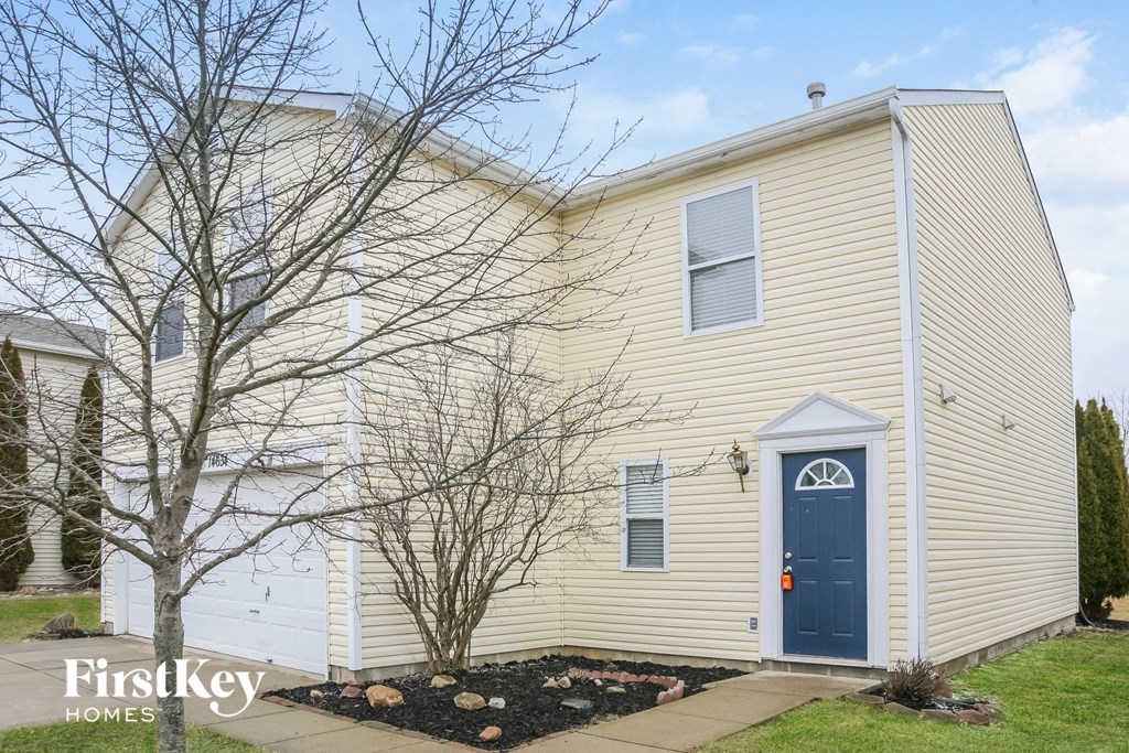 the front of a yellow house with a blue door