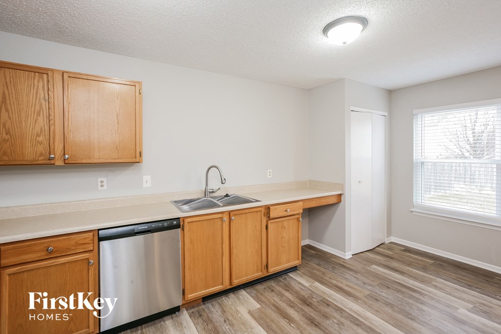 a kitchen with wooden cabinets and a stainless steel dishwasher