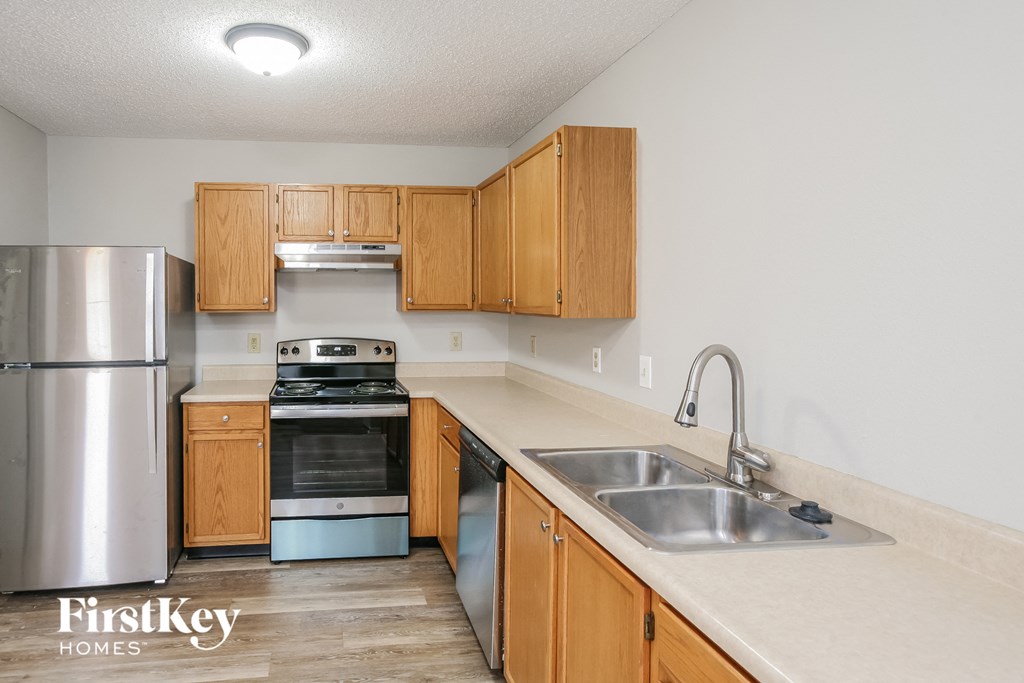 a kitchen with wooden cabinets and stainless steel appliances and a sink