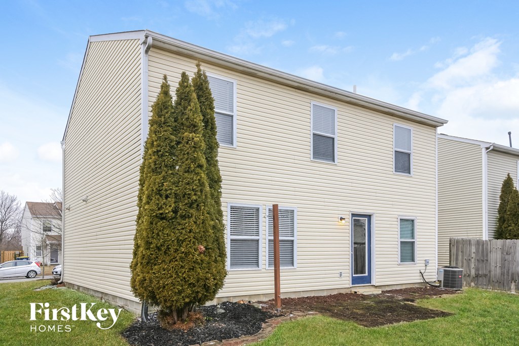 a white house with a blue door and a christmas tree