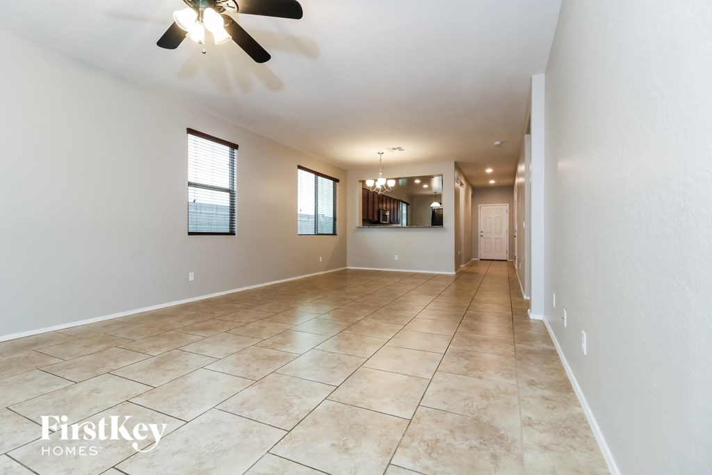 A spacious room with a fan and tiled flooring.