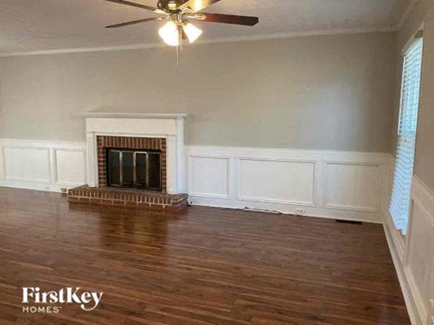 a living room with a fireplace and a ceiling fan