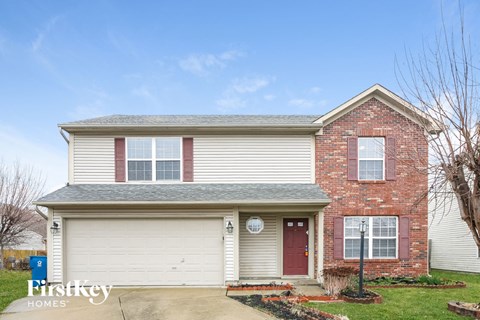 a white and red brick house with a white garage door