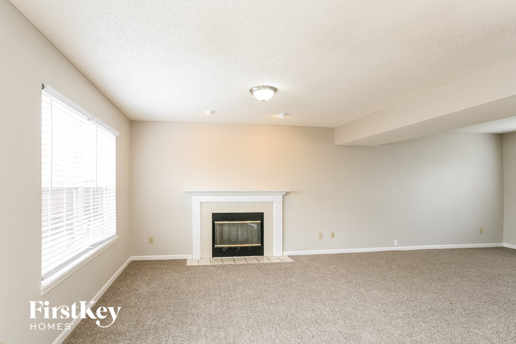 a living room with a fireplace and a large window