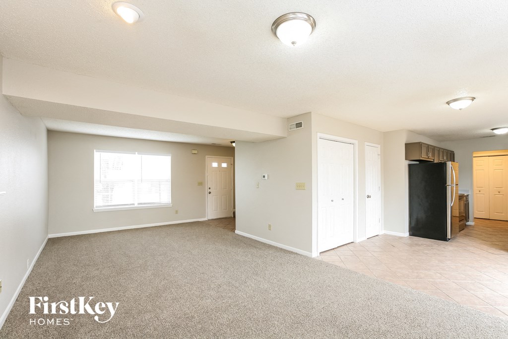 the living room and dining room with the kitchen in the background