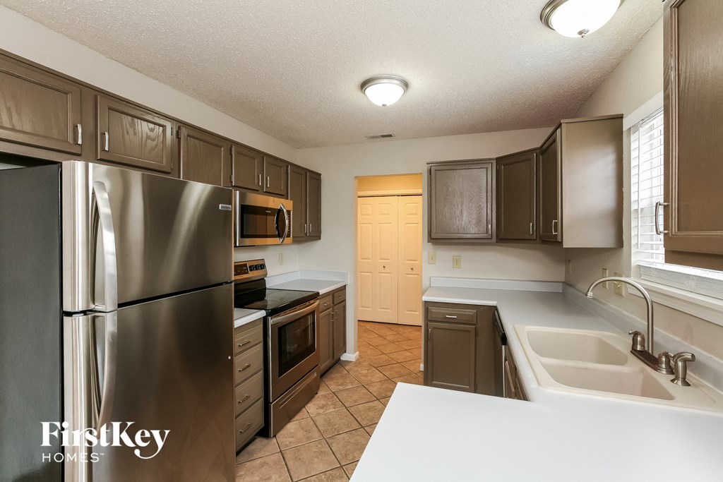 a kitchen with stainless steel appliances and white counter tops